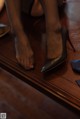 A woman's feet in high heels on a wooden floor.