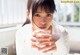 A woman holding a glass of water in her hand.