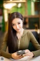 A woman sitting at a table looking at her phone.