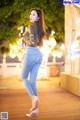 A woman standing on a wooden walkway next to a carousel.