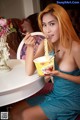 A woman sitting at a table eating a bowl of noodles.