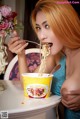 A woman eating a bowl of noodles with a spoon.