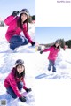 A woman in a pink jacket crouching down in the snow.