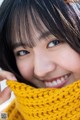 A woman wearing a yellow scarf smiles at the camera.