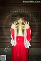 A woman in a red and white kimono posing for a picture.