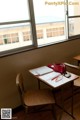 A desk with a red purse sitting on top of it next to a window.