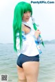 A woman with long green hair standing in the water.