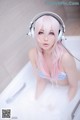 A woman in a bathtub with headphones on.