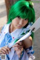 A woman with green hair holding a knife.