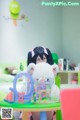 A girl sitting at a table holding a stuffed animal.