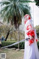 A woman dressed in a white and red kimono holding a sword.