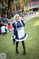 A woman dressed in a maid outfit holding a gun.