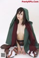 A woman in a green cloak is posing for a picture.