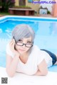 A woman laying on the edge of a swimming pool.