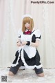 A woman in a maid outfit is posing for a picture.