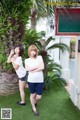 A couple of women standing next to each other in front of a sign.