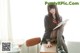 A woman sitting at a desk reading a book.