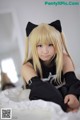 A woman with long blonde hair and a black cat ears.