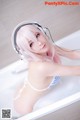 A woman in a bathtub with headphones on.