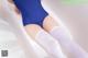 A woman in a blue leotard and white stockings.