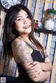 A woman with a tattoo on her arm posing for a picture.