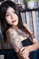 A woman with a tattoo on her arm posing for a picture.