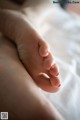 A close up of a person's foot on a bed.