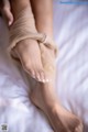 A close up of a woman's bare feet on a bed.