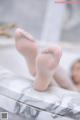 A woman's feet in a bathtub with her feet on the edge of the tub.