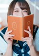 A woman in a sailor outfit holding a book.