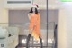 A woman in an orange dress and a santa hat posing for a picture.