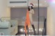 A woman in a santa hat is standing on a bed.