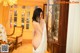 A naked woman standing in front of a mirror in a room.