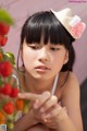 A young woman holding a bunch of tomatoes in her hand.