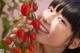 A woman holding a bunch of cherry tomatoes in her hand.