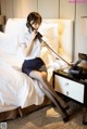 A woman sitting on a bed talking on a phone.