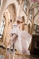 A woman in a white dress playing a violin.