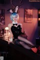 A woman in a bunny costume sitting at a bar.