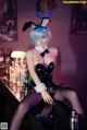 A woman in a bunny costume sitting at a bar.