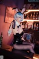 A woman in a bunny costume sitting at a bar.