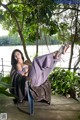 A woman laying on a chair under a tree.