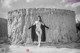 A naked woman standing in front of a wall.