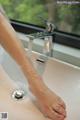 A woman's feet are being washed in a sink.