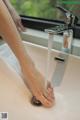 A woman's feet are being washed in a sink.