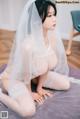 a woman in a white lingerie sitting on a bed