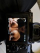 A camera with a picture of a woman on the screen.