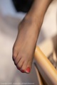 A close up of a woman's feet with red nail polish.