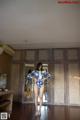 A woman in a blue and white bathing suit standing in front of a mirror.