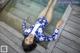 A woman laying on a wooden dock next to a pool.