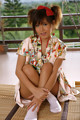 A woman in a kimono sitting on a bamboo mat.